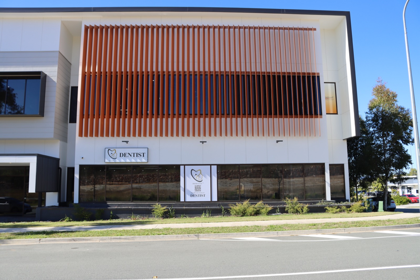 FB Dental Yarrabilba building with orange slat facade and DENTIST sign on Adler Circuit
